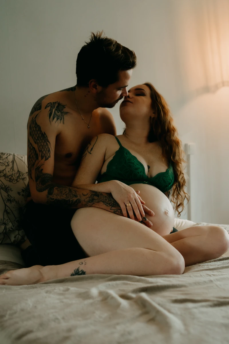 Photo grossesse lifestyle couple enlacé sur lit, moment tendre et naturel