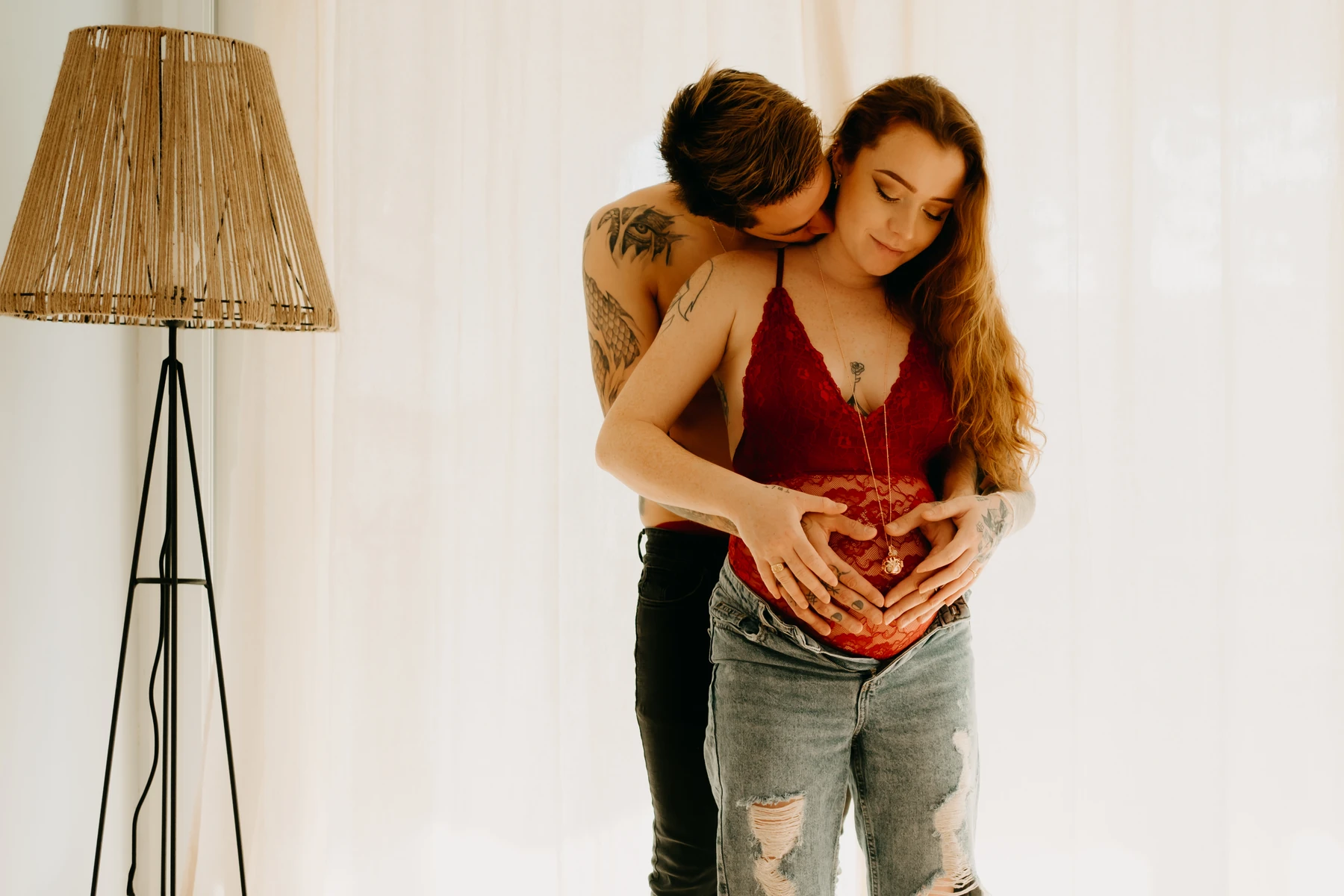 Photo grossesse naturelle – futur papa enlace et embrasse tendrement le ventre rond