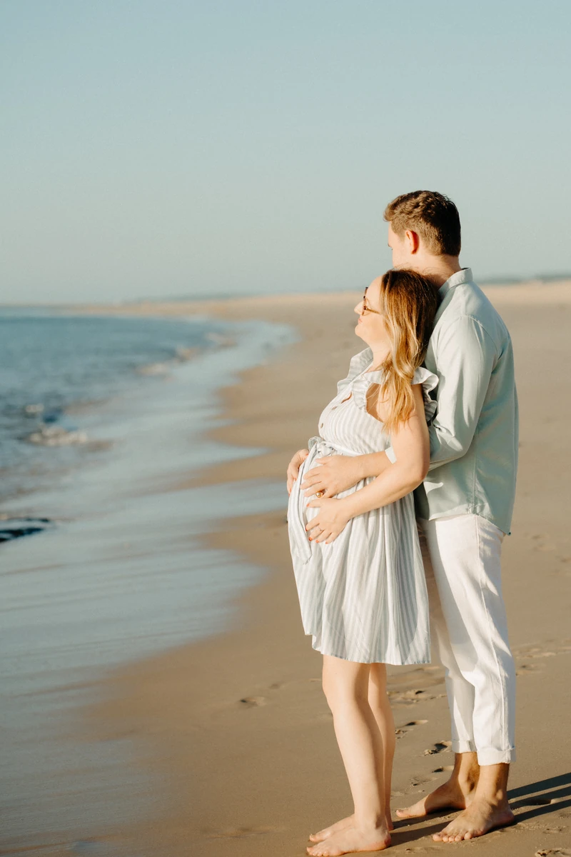 couple regardant l’horizon lors d’une séance photo grossesse sur la plage du Petit Nice au Pyla