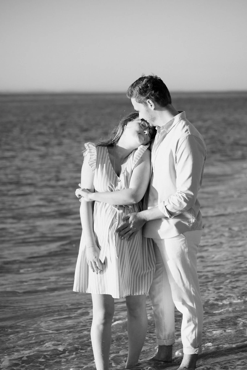 séance photo grossesse en couple au Pyla, moment tendre sur la plage en noir et blanc
