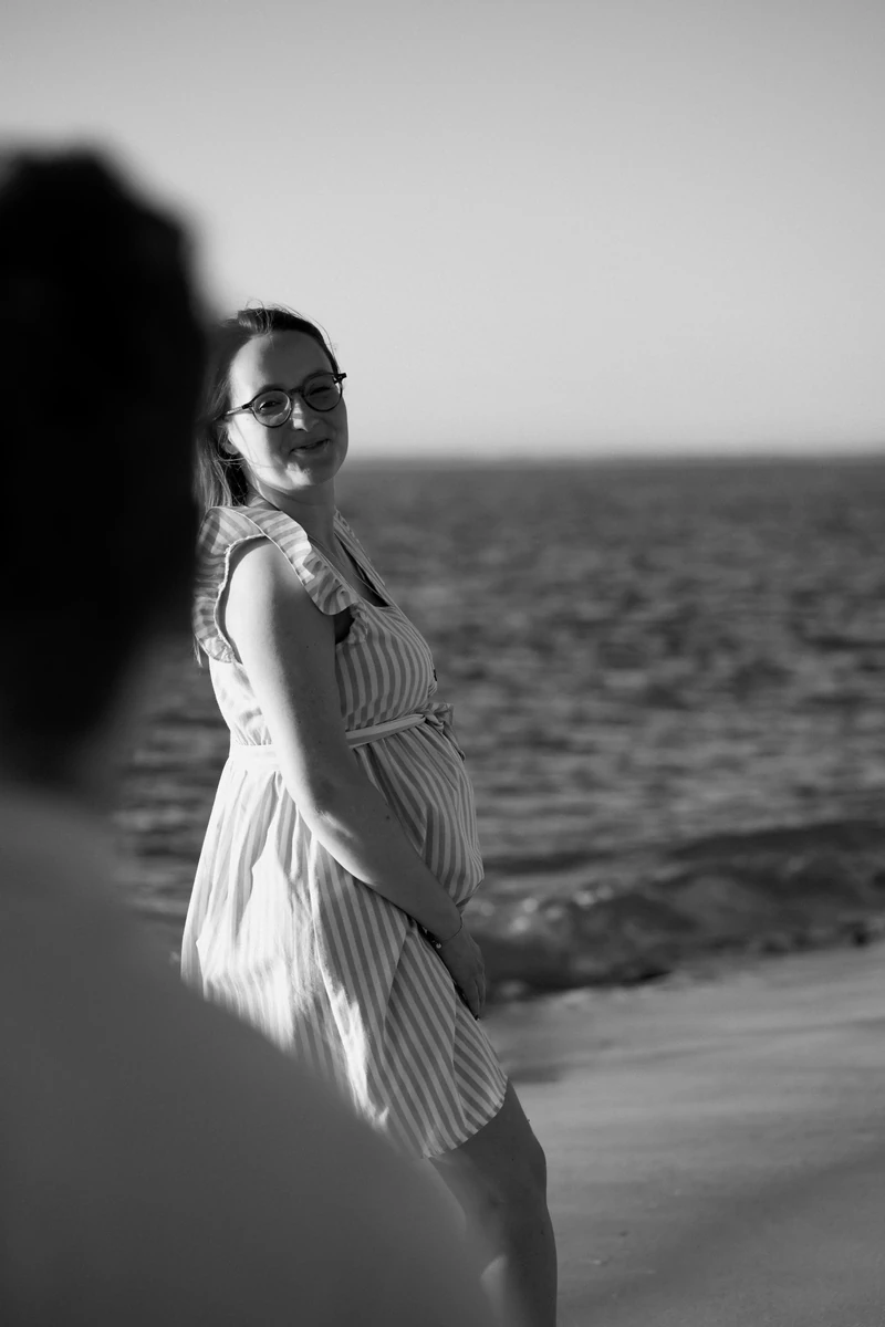 photo grossesse noir et blanc à Pyla-sur-Mer, future maman souriante au bord de l’eau