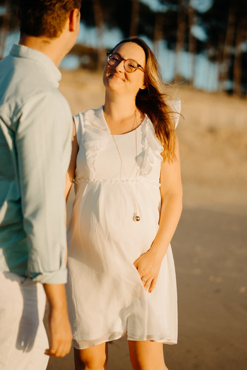 photo de grossesse naturelle sur la plage du Petit Nice, future maman souriante face à son compagnon au Pyla-sur-Mer