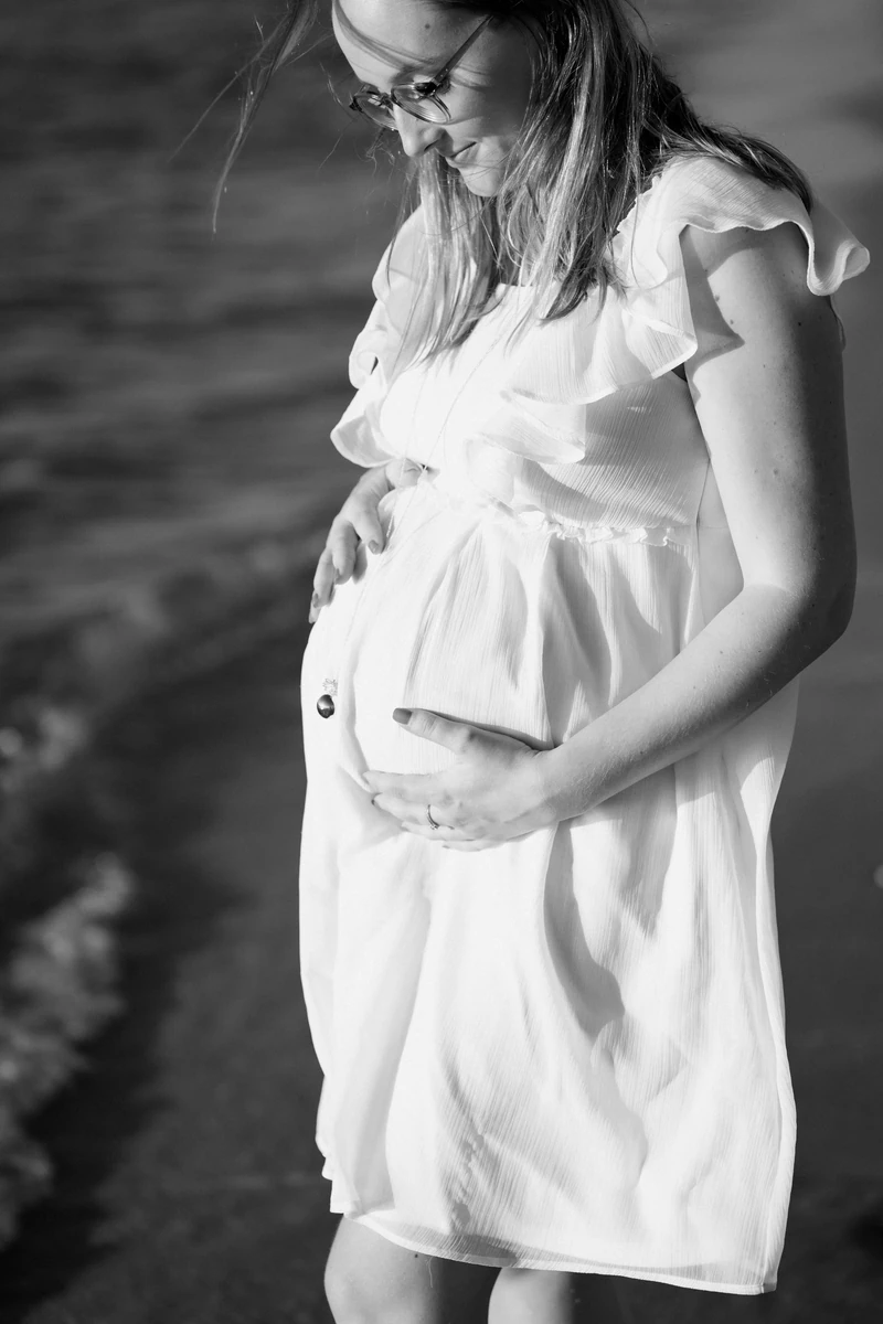 photo grossesse artistique bord de mer au coucher du soleil sur la plage du Petit Nice à Pyla-sur-Mer, future maman sereine en robe blanche