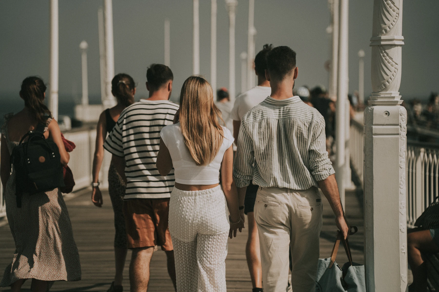 Séance photo de couple à Arcachon, marche romantique sur la jetée animée un matin d’été.