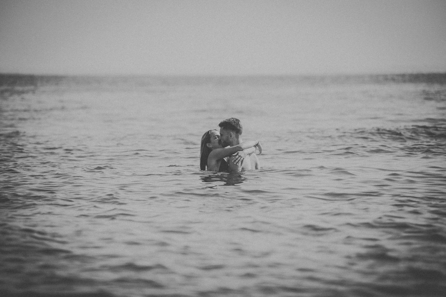 Photo de couple enlacé dans l’eau en pleine matinée sur la plage du Bassin d’Arcachon.