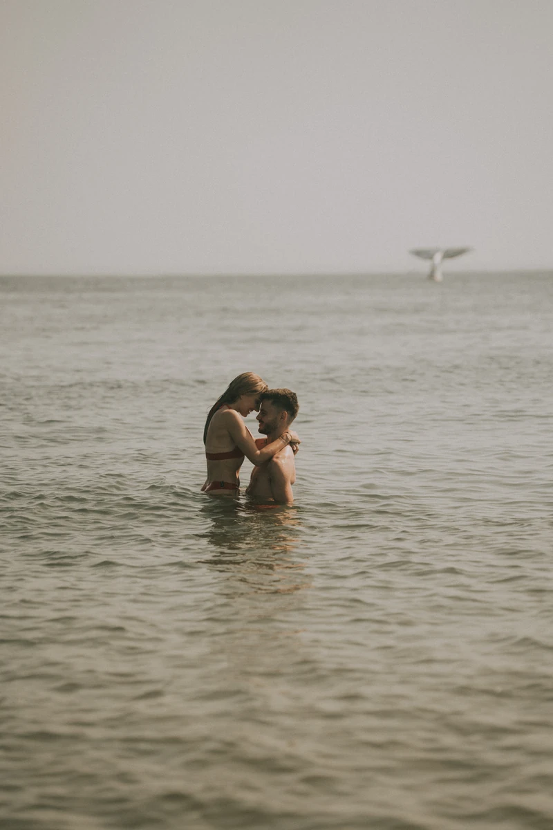 Séance photo couple romantique dans l’eau à Arcachon, Marine et Théo enlacés en maillot au cœur du Bassin.